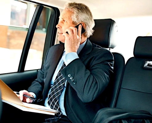passager profite de la qualité du taxi pour voyage affaire passager homme d'affaire assis à l'arrière du taxi avec des documents sur les genoux
